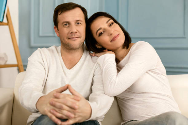 istock Delighted joyful couple sitting together 1003294370