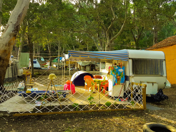 istock campinng tent forest caravan trailer  summer season 1003306388