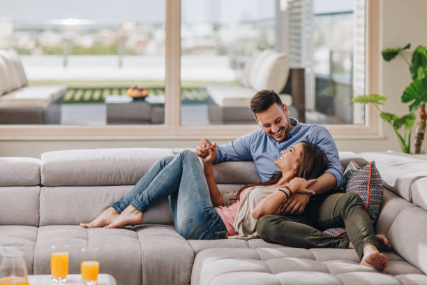istock Happy couple in love resting on the sofa and communicating. 1003307498