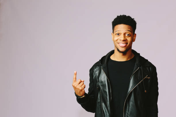 istock Cool guy smiling at the camera and pointing up 1003312354