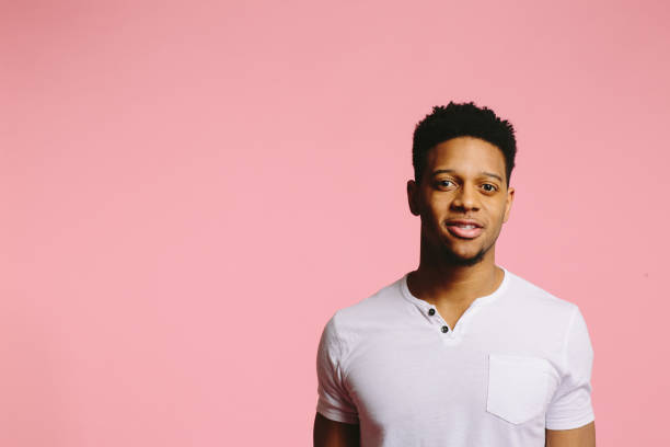 istock Young man looking at camera with interest, on pink 1003312480