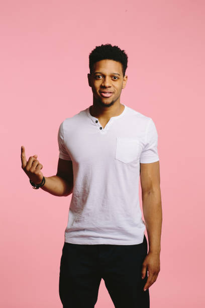 istock Vertical portrait of an attractive cool guy pointing and looking at camera 1003312482