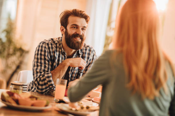 istock Happy man talking to his girlfriend during their meal at dining table. 1003312820