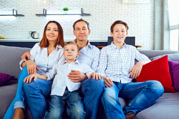 istock Happy family smiling sitting on sofa in room 1003319044