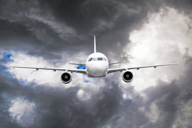 avion de passager vole dans la zone de turbulence au moyen de la foudre des nuages d’orage lors d’intempéries. - turbulence photos et images de collection