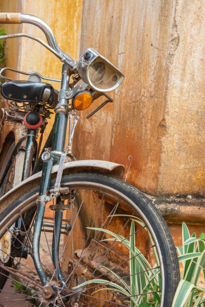 istock Old classic antique rusty bicycle on vintage rustic Yellow Brick Wall background. 1003322862