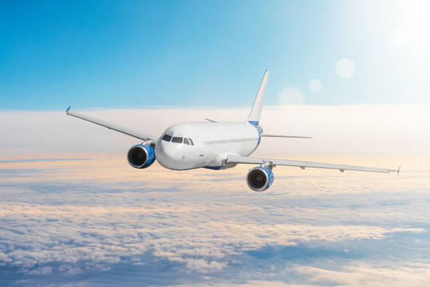 istock Flying airplane above the clouds horizon sky with bright sunset colors. 1003325464