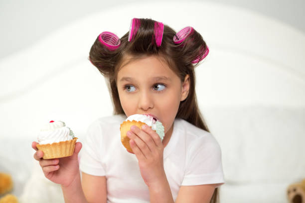 istock Cute girl eating cupcake 1003328438