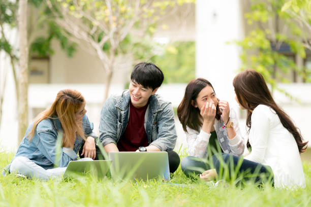 education, school and people concept - Cheerful university students with notebook and phone; Asia university. stock photo