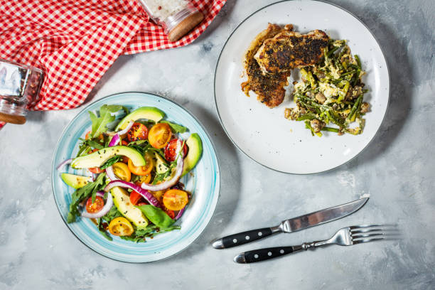 istock Salad with tomatoes and avocado and Grilled beef steak on concrete background. 1003331920
