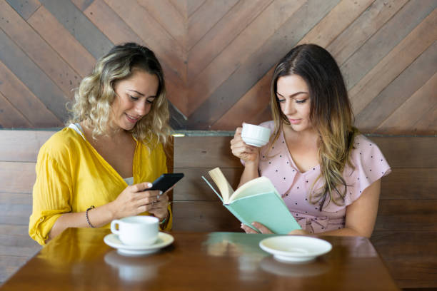 istock Two attractive young women drinking coffee and resting in cafe 1003332572