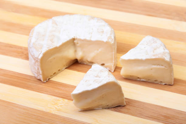 istock Cheese with white mold. Camembert or brie type on wood table. Healthy breakfast. 1003335876