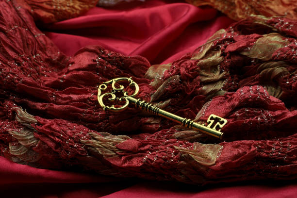 istock Golden Vintage Luxury Key on Red Royal Fabric 1003339118
