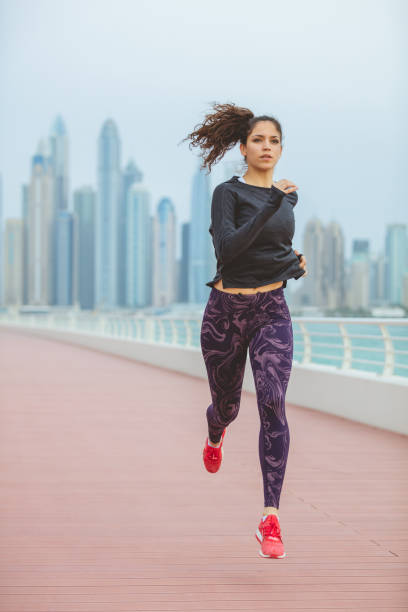 istock Young female running along the pier 1003342946
