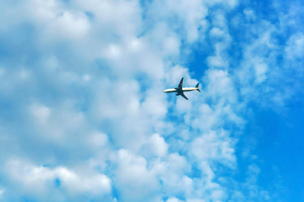 istock white clouds in the blue sky and passenger plane, plane in the sky with clouds 1003353576