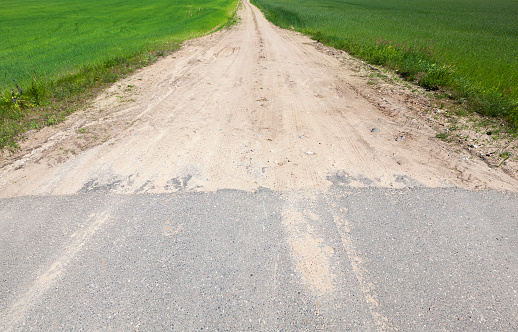 The place where an asphalt road and sandy road connects, closeup