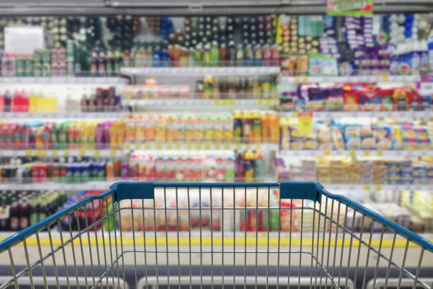 istock Supermarket aisle with empty shopping cart 1003357078
