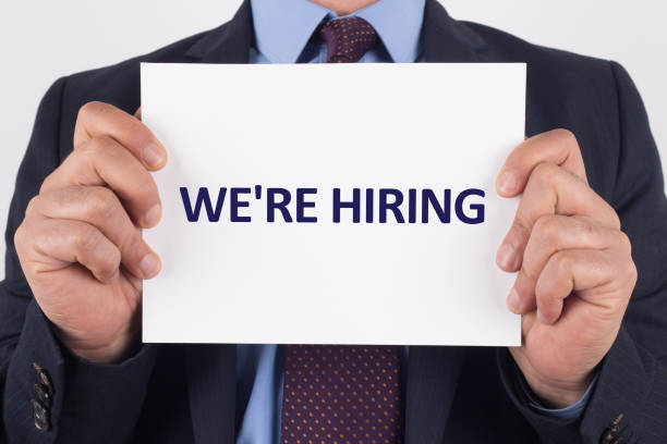istock Man showing paper with WE'RE HIRING text 1003364360