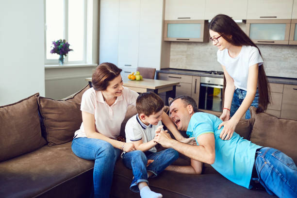 istock The family plays together fun on the couch 1003365454
