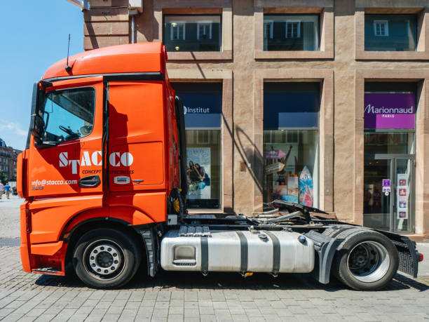 Red Mercedes Benz Actros truck parked in City Strasbourg: New powerful Mercedes-Benz Actros truck parked on city street near shopping stores - side view mercedes argentina stock pictures, royalty-free photos & images