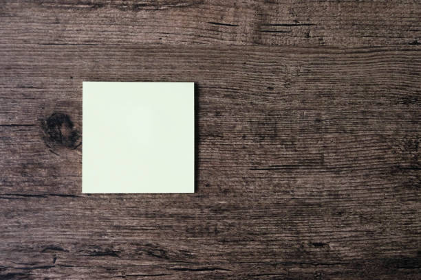istock Top view image of empty sticky note paper on the wooden table. 1003369490