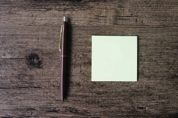 istock Top view image of empty sticky note paper and pen on the wooden table. 1003369502
