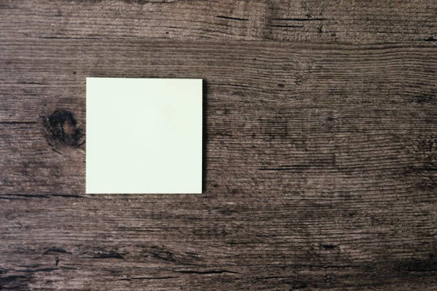 istock Top view image of empty sticky note paper on the wooden table. 1003375550