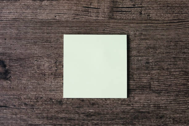 istock Top view image of empty sticky note paper on the wooden table. 1003379256