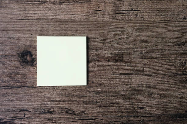 istock Top view image of empty sticky note paper on the wooden table. 1003379274