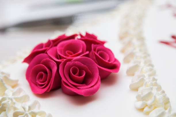 Piece of wedding cream soft cake with decoration from roses close-up
