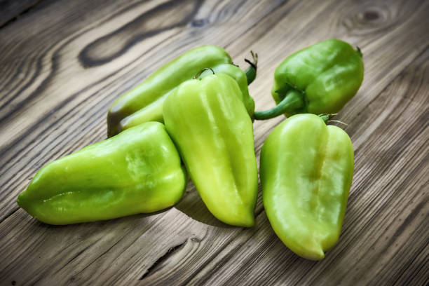 istock fresh green peppers on wooden background 1003389556