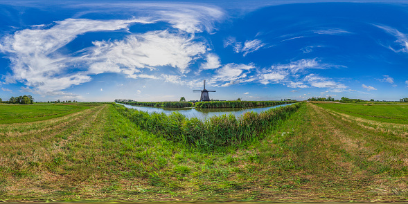 360 degrees spherical panoramic shot of the old antique windmill against a cloudy sky; South Holland