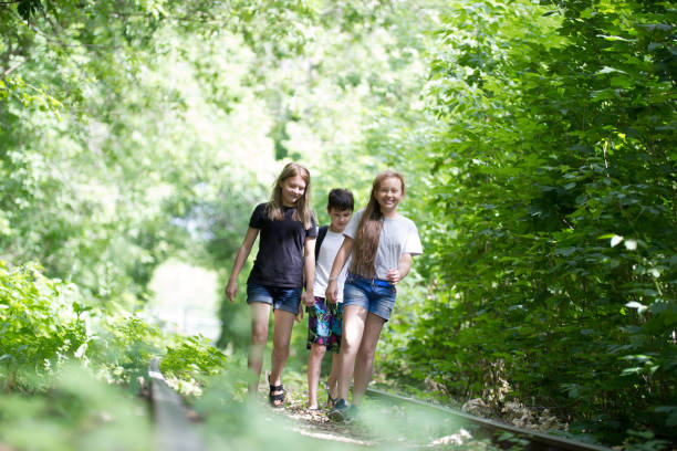 istock Children walking in the woods on an abandoned railway 1003394244