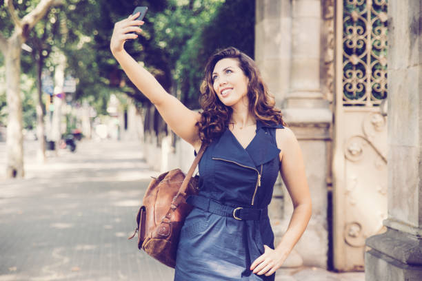 istock Cheerful young woman taking selfie at ancient gate 1003395384