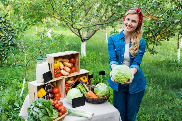 istock attractive farmer showing cabbage at farmer market 1003403584
