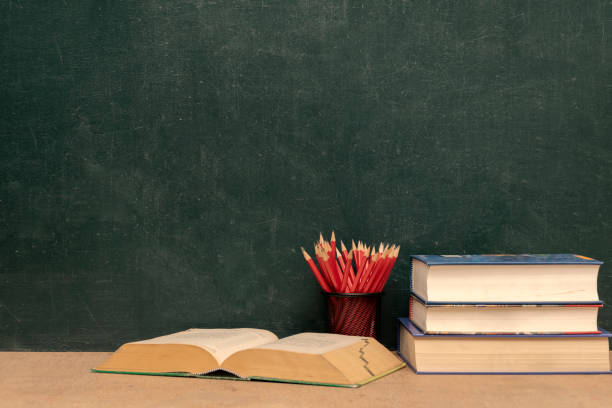 Success concept, pencils over chalkboard background, Books stacked and books open. Red pencil put Pencil holder.Learn to develop yourself.