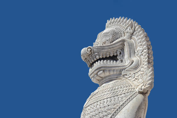istock sculpture of ancient white stone singha statue isolated on blue sky background in front of temple in Bangkok, Thailand , Southeast Asia 1003408928