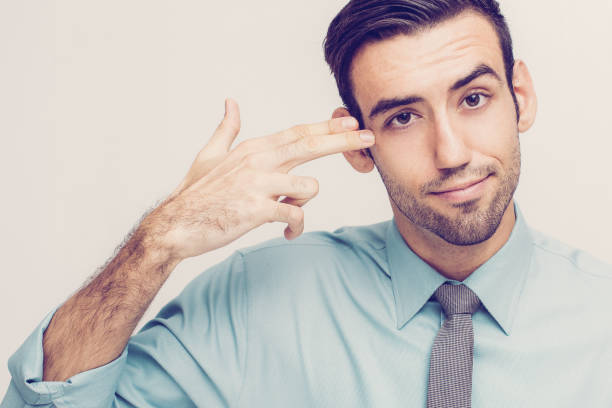 istock Playful Business Man Shooting Himself With Fingers 1003411182