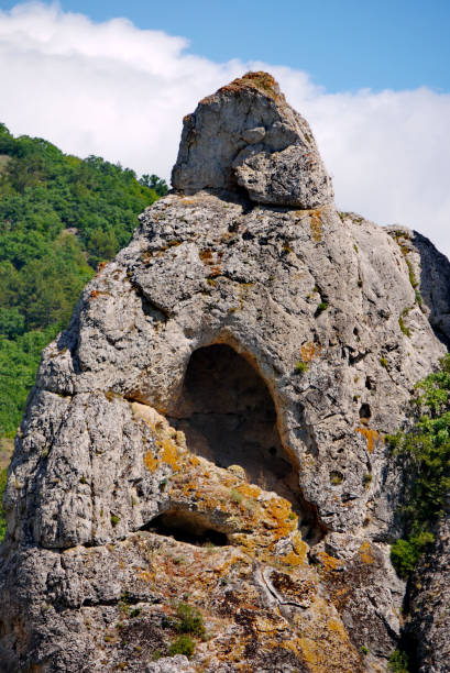istock A gray rock with a red moss and a cave in it 1003412036