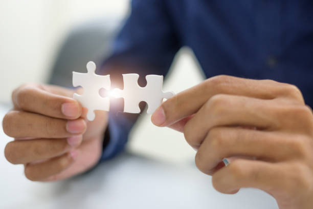 istock Midsection Of Mann Holding Jigsaw Piece 1003412236
