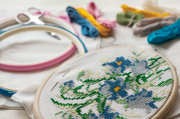 istock Close up stitching pattern on white fabric with colorful yarn on background 1003412988