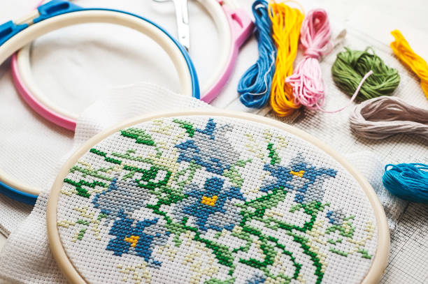 istock Close up stitching pattern on white fabric with colorful yarn on background 1003413064