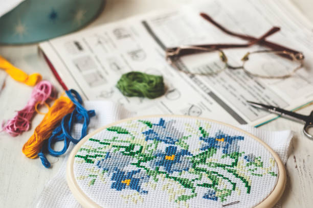 istock Close up stitching pattern on white fabric with colorful yarn on background 1003413102