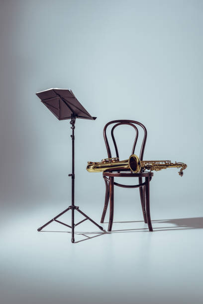 istock music stand for notes and professional saxophone on chair on grey 1003417082