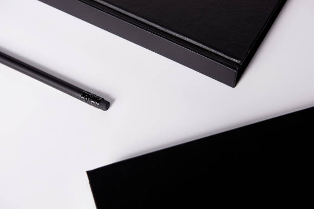 istock close-up shot of black notebooks with pencil on white surface for mockup 1003422662