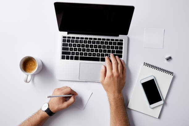 istock cropped shot of man working with laptop at workplace on white surface for mockup 1003422888