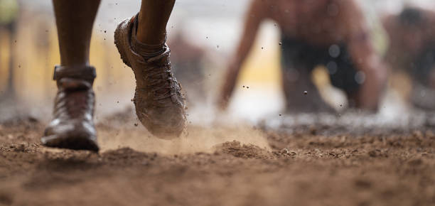 Mud race runners Mud race runners.Crawling,passing under a barbed wire obstacles during extreme obstacle race obstacle course stock pictures, royalty-free photos & images