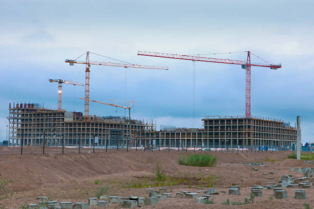 istock big building with tower cranes on blue sky background 1003423568