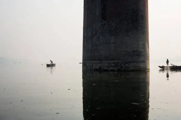 Photo of Fishing boat silhouette with Mawlamyine Malviya Bridge background