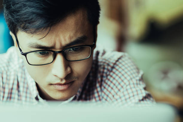 istock Concentrated man in glasses looking at screen 1003426450
